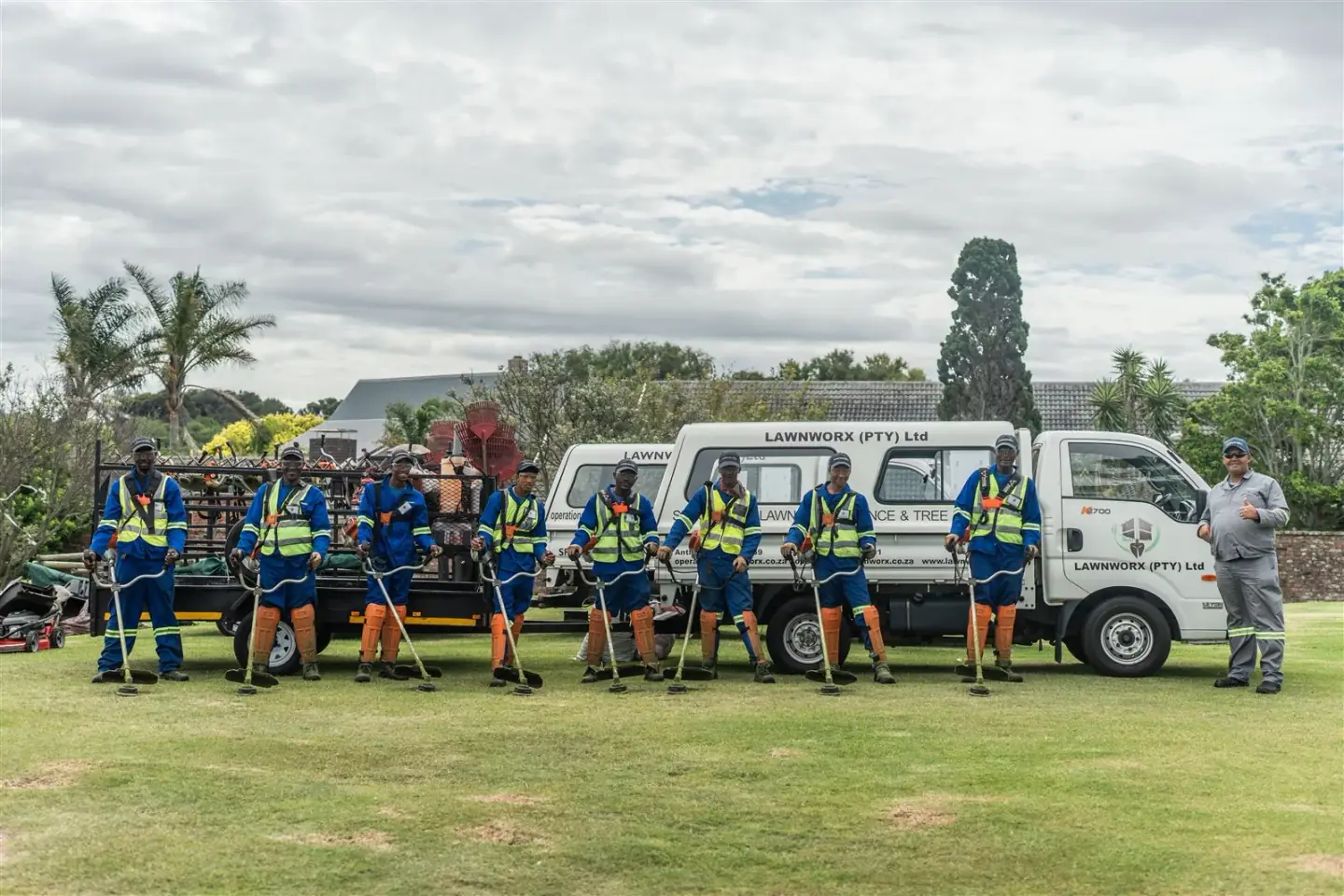 Lawnworx team with branded company vehicle and grounds maintenance equipment